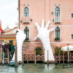 Huge replicas of human hands pretending to support a building