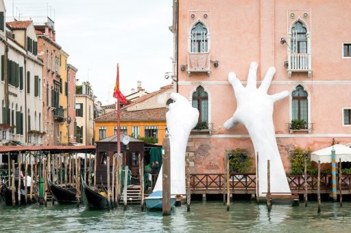 Huge replicas of human hands pretending to support a building