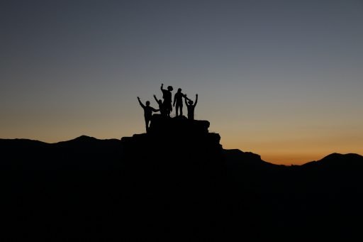 team reaching top of a hill