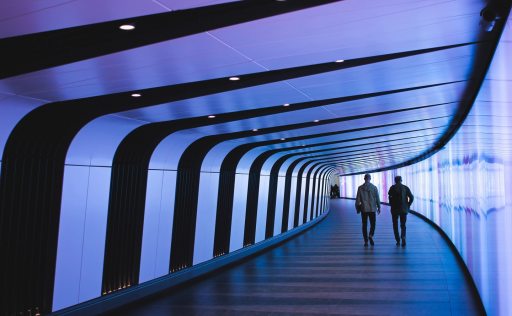 Two people walking in futuristic tunnel