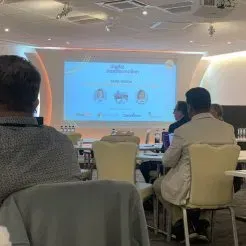 room with people on chairs looking at screen
